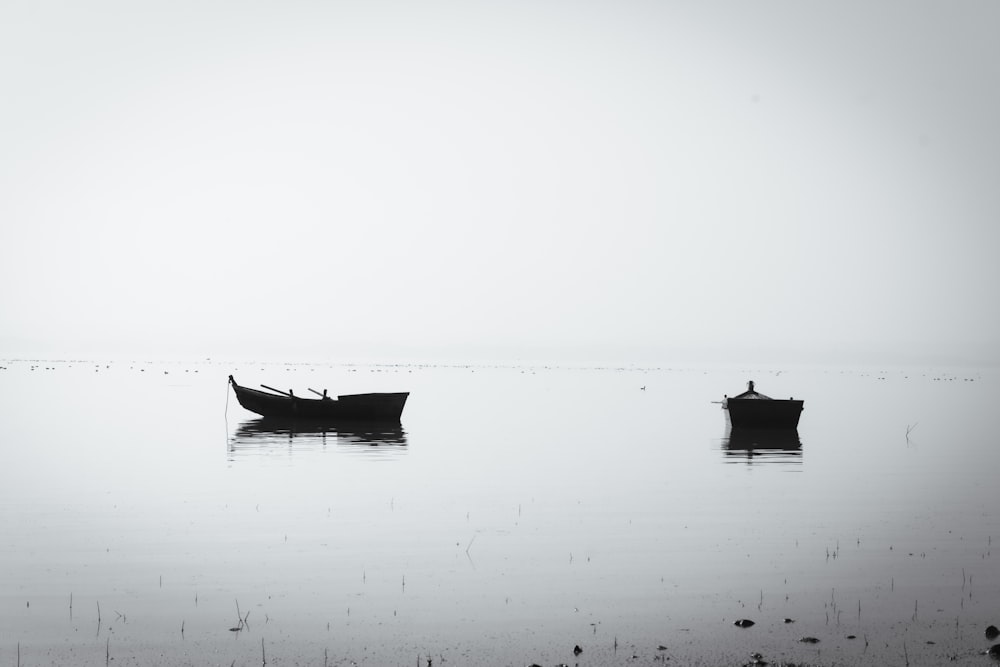 a couple of boats floating on top of a lake