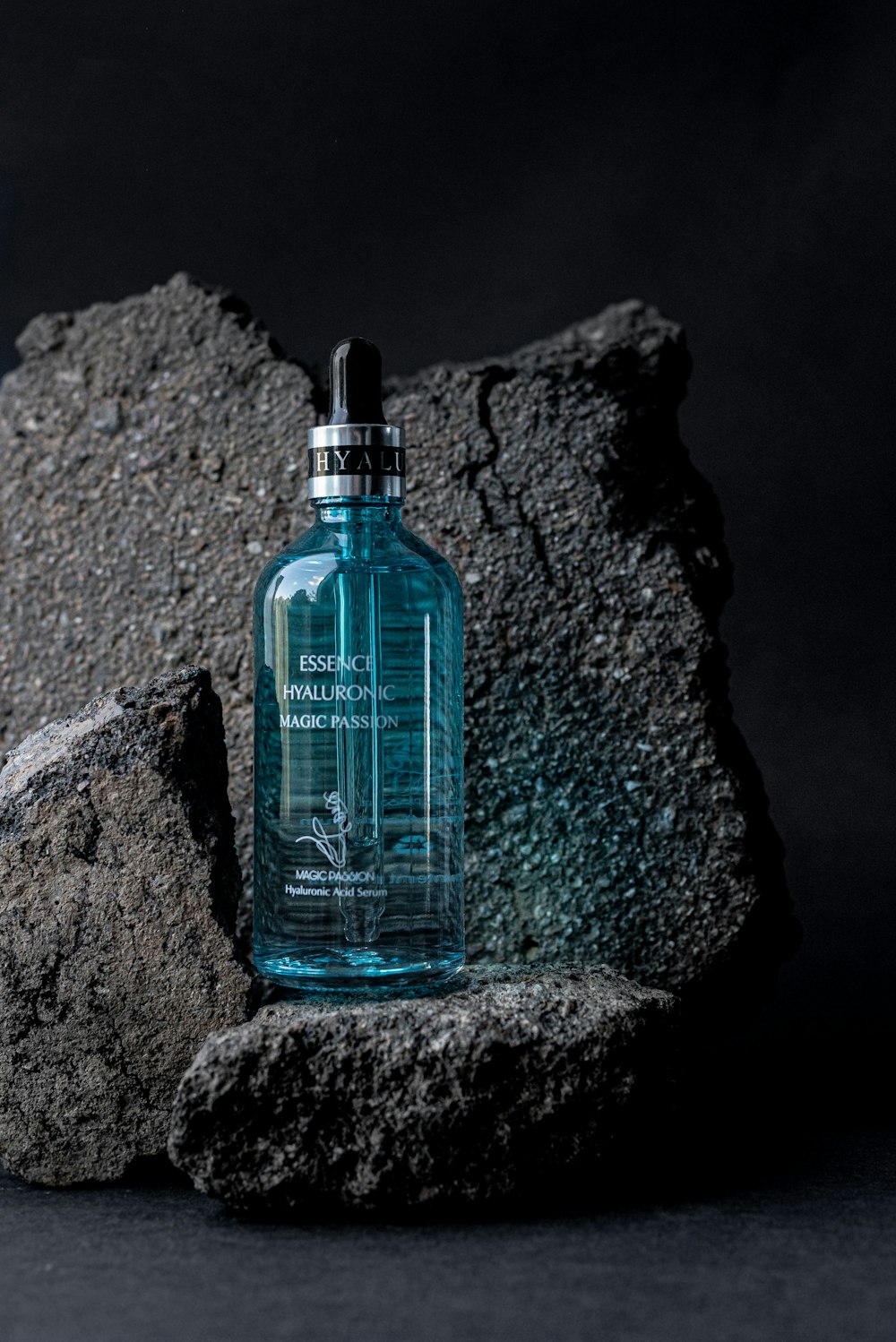 a bottle of cologne sitting on top of a rock
