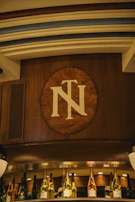 Elegant wooden engraved name plate with intricate detailing displayed on a rustic wall.