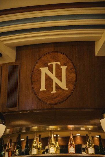 A regal wooden plaque wall with engraved names and titles, glowing softly under warm lighting.