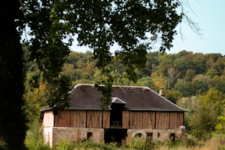Rustic timber frame barn with natural wood grain and moss-covered roof.