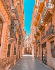 a narrow city street lined with buildings and balconies