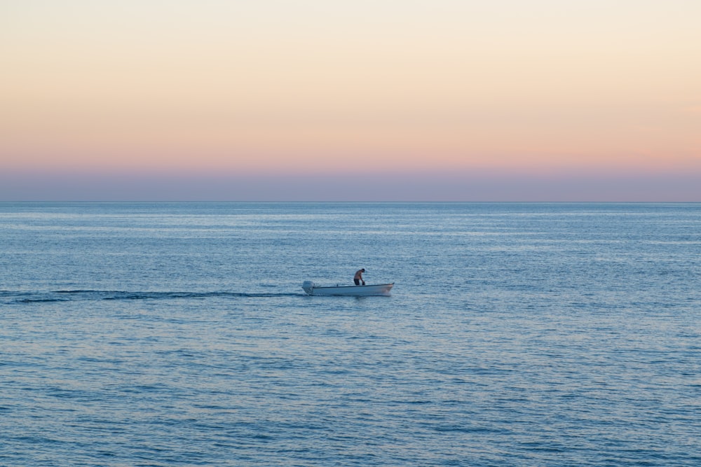 uma pessoa em um pequeno barco no meio do oceano