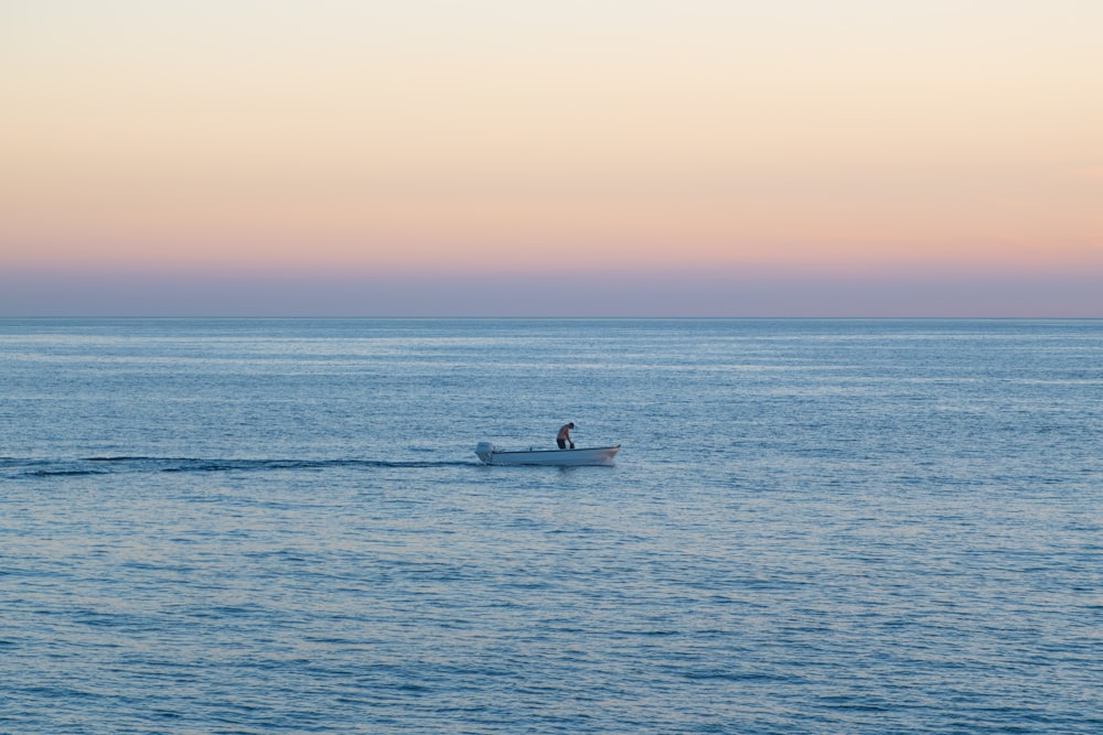 a person in a small boat in the middle of the ocean