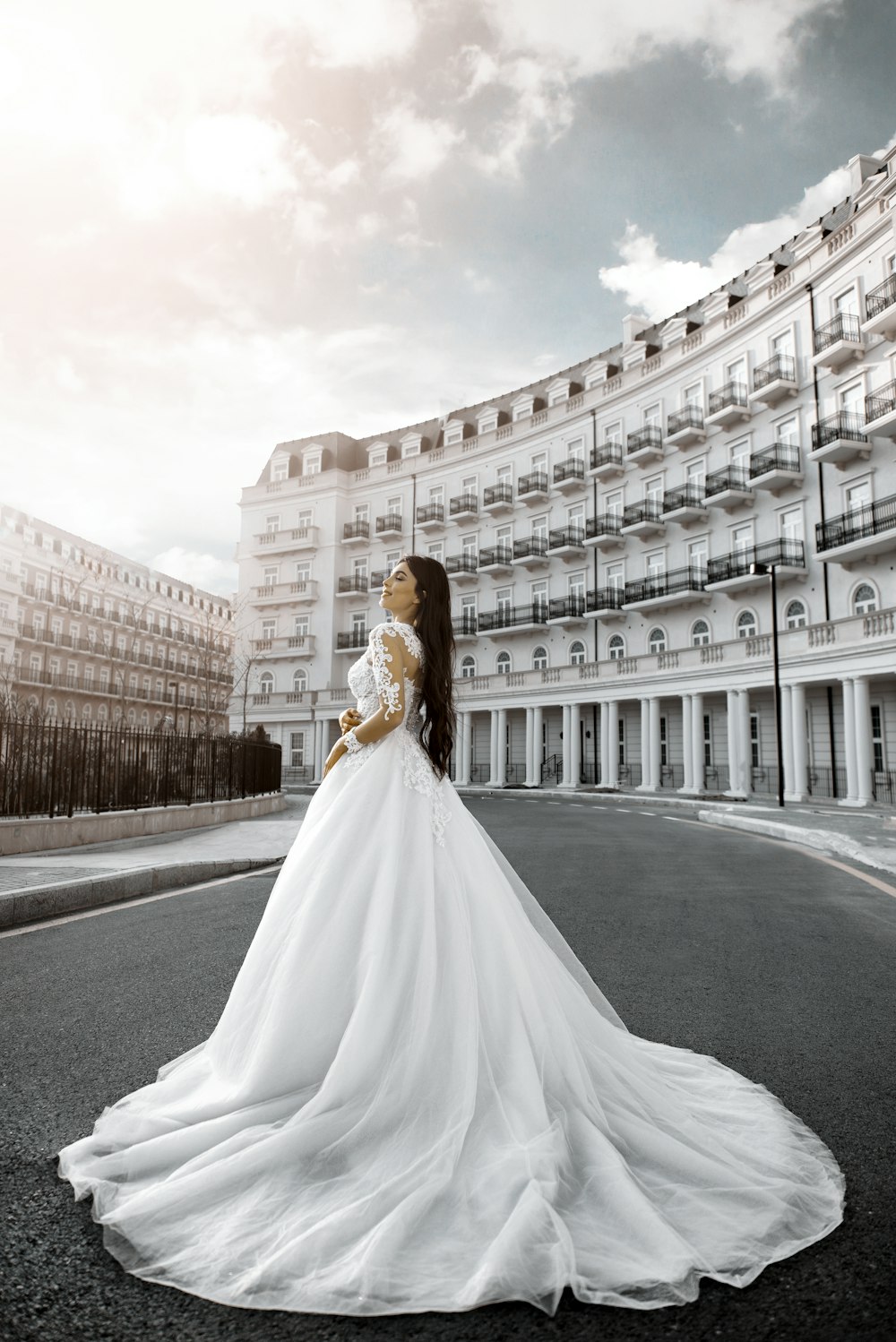 a woman in a wedding dress standing on a street