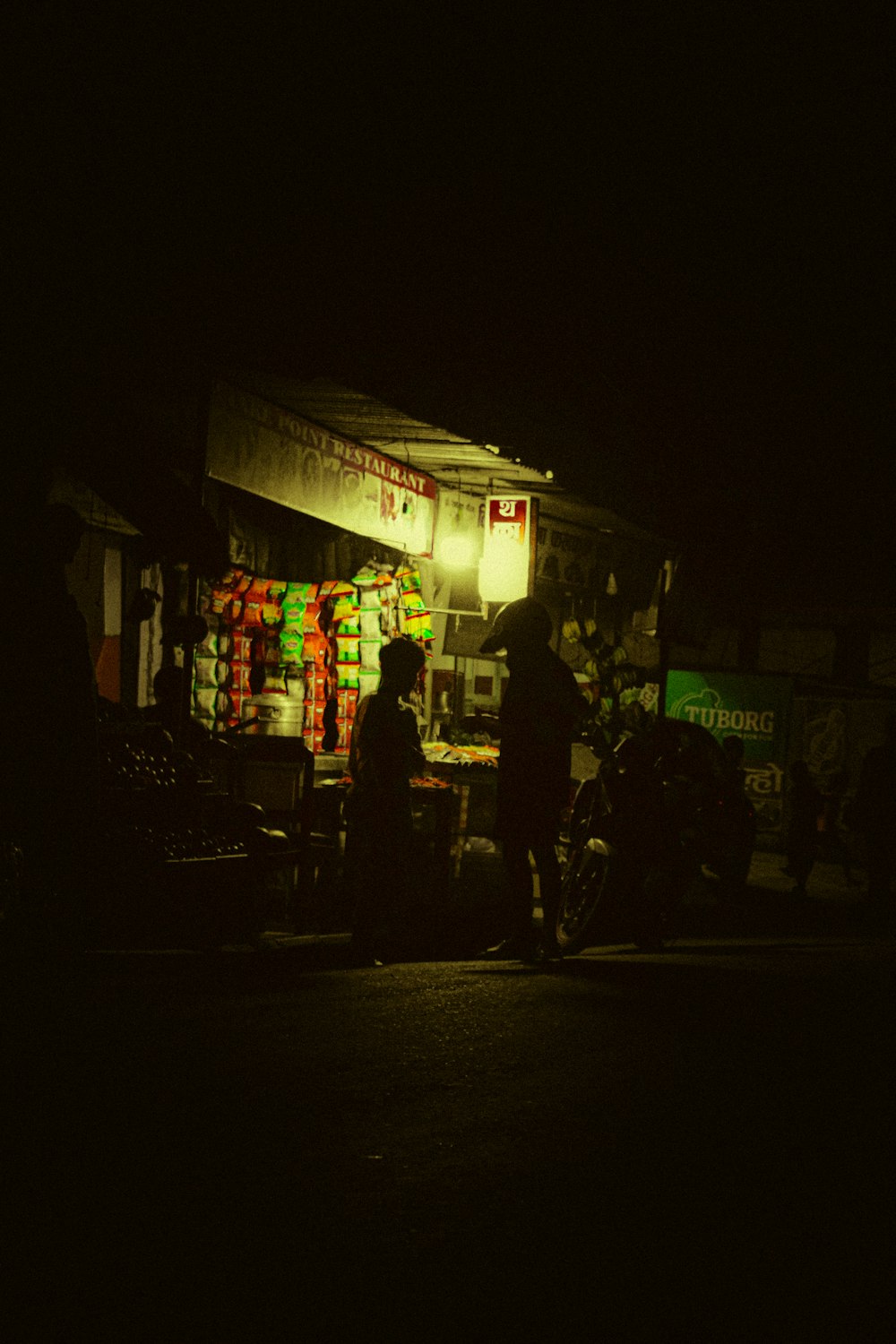 una persona in piedi di fronte a un negozio di notte