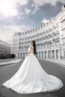 A bride’s delicate lace dress flowing softly in the breeze against a backdrop of ancient stone walls.