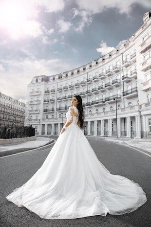 A bride’s delicate lace dress flowing softly in the breeze against a backdrop of ancient stone walls.