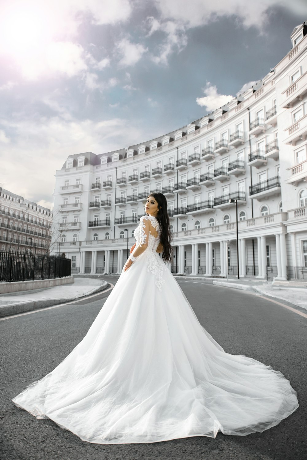 a woman in a wedding dress standing on a street