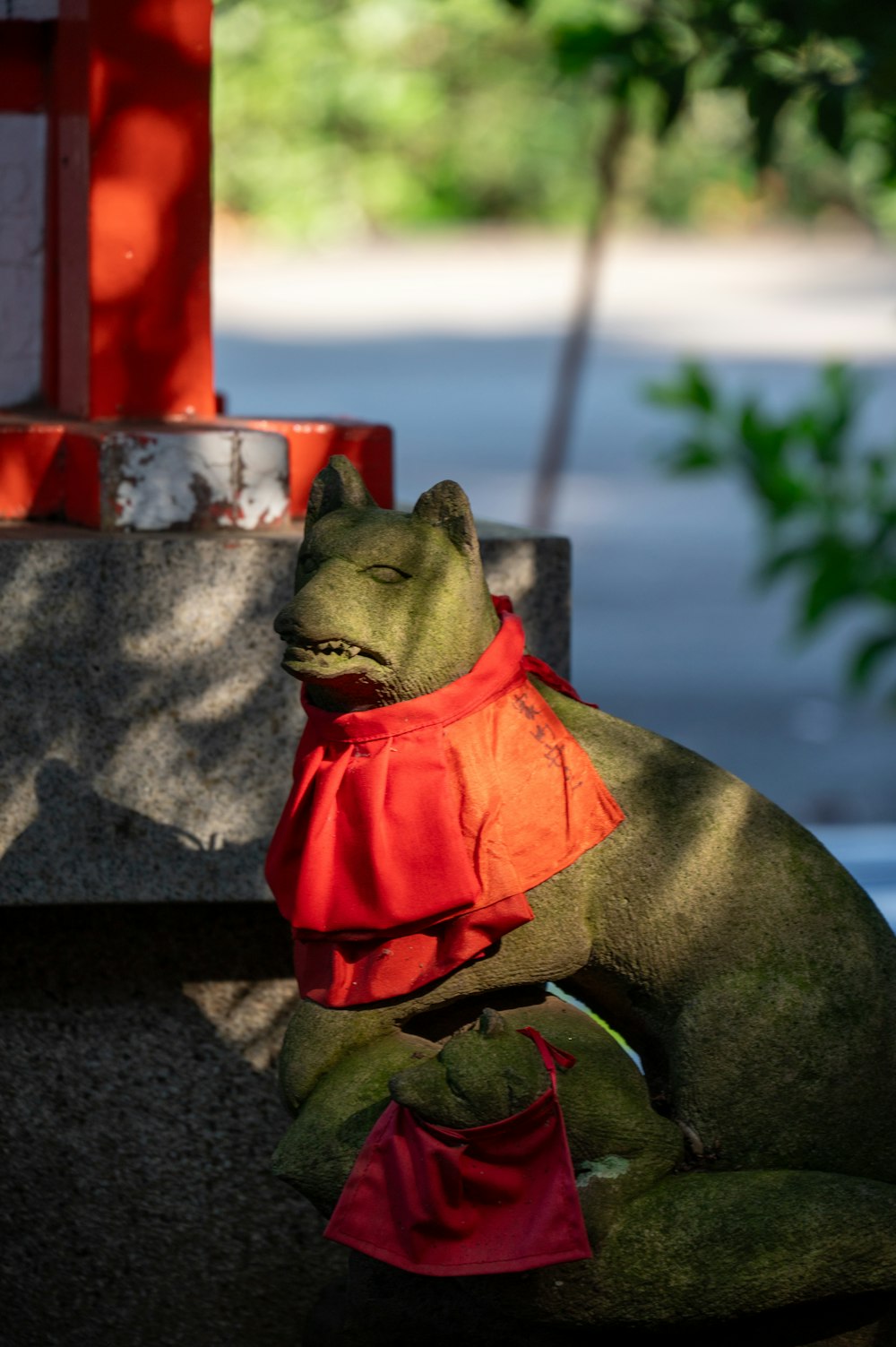 a statue of a cat with a red scarf around its neck