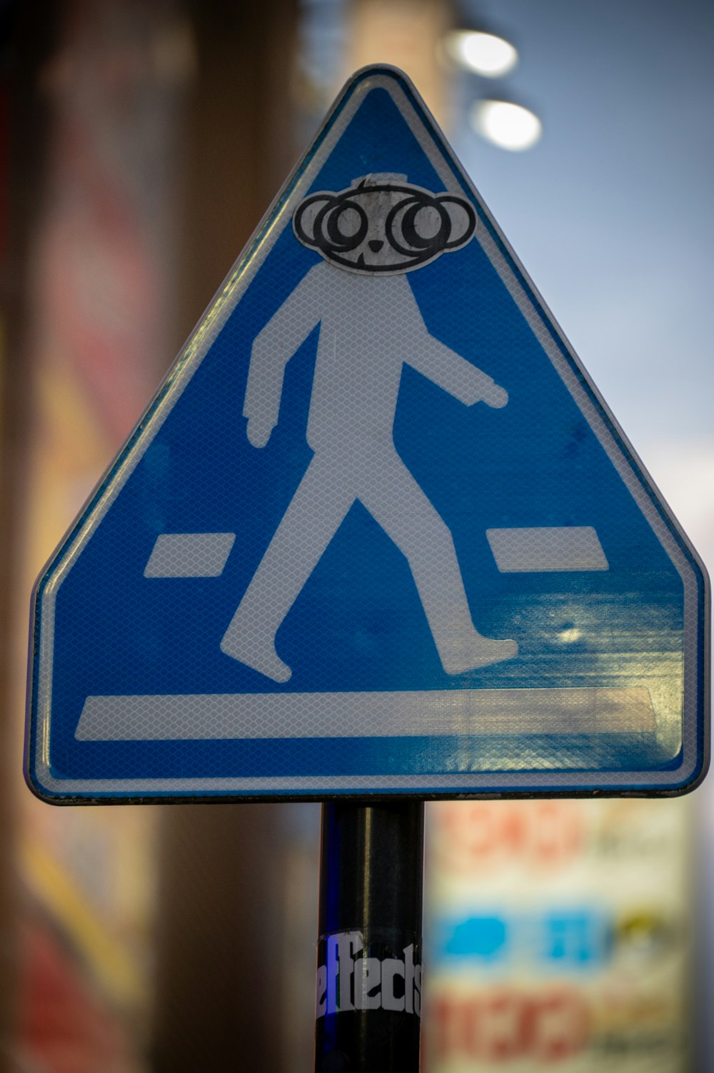 uma placa de rua com um adesivo de um homem andando