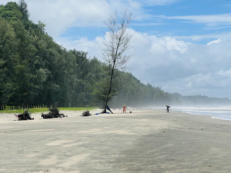 a group of people standing on top of a sandy beach