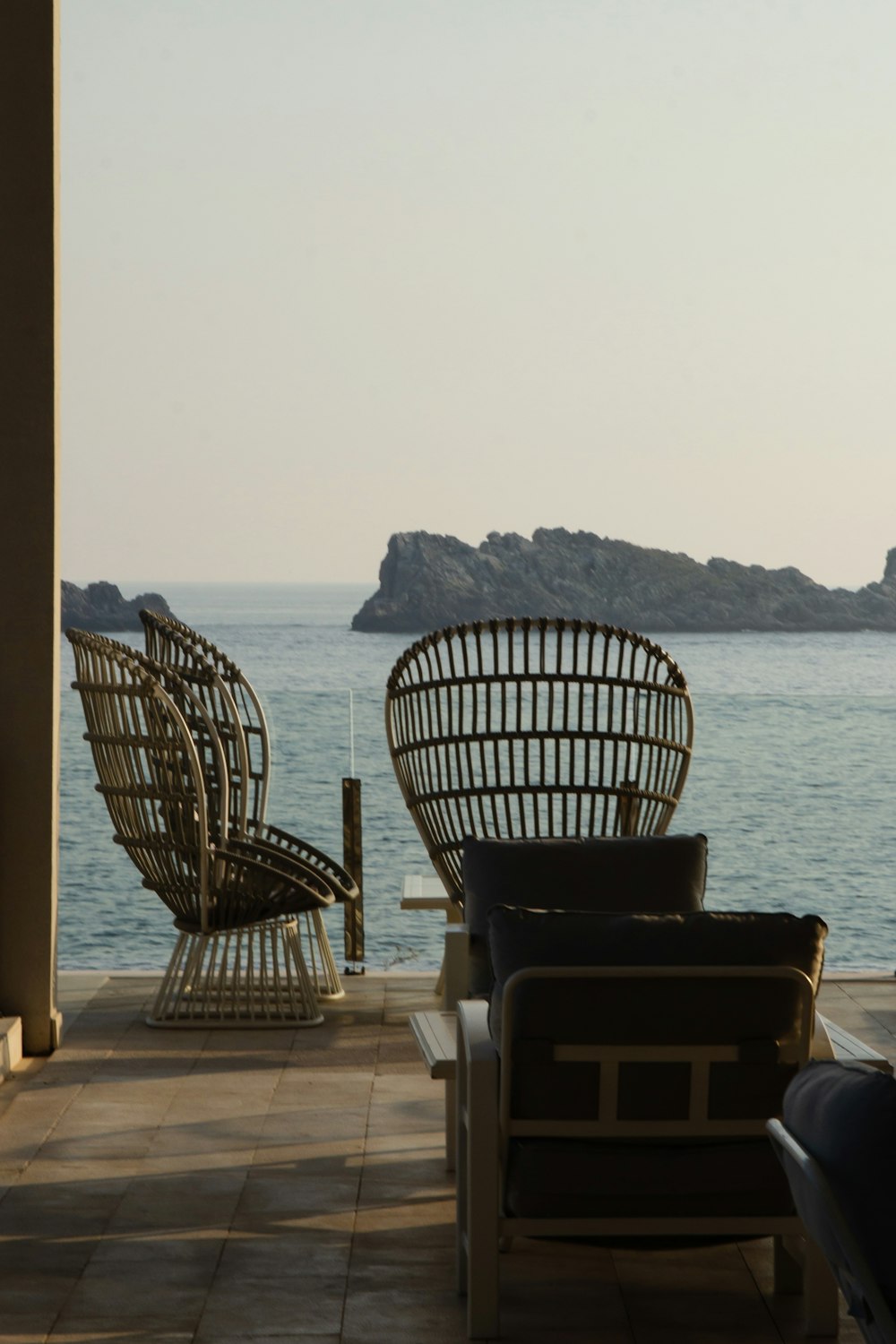 a couple of chairs sitting on top of a patio next to a body of water