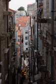 A narrow stone alley in Nizwa bustling with locals during a cultural walking tour.