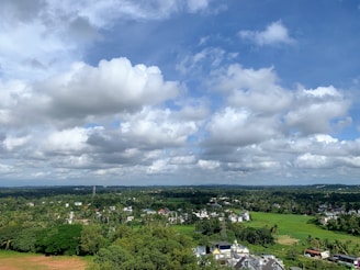 A spacious 5 kanal farmhouse plot surrounded by lush greenery under a clear blue sky.