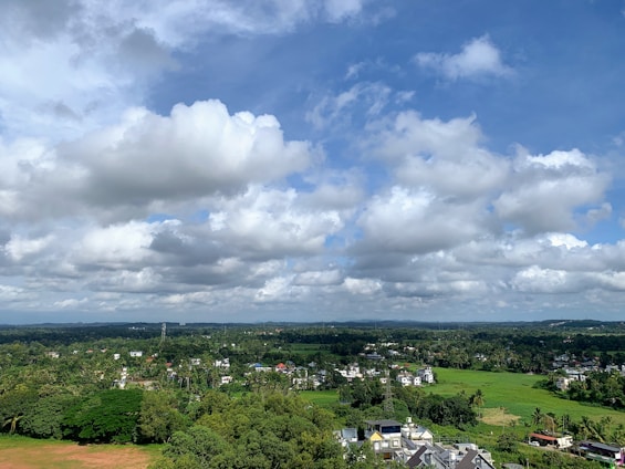 A spacious 5 kanal farmhouse plot surrounded by lush greenery under a clear blue sky.