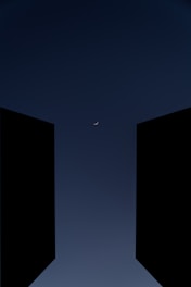 two open doors with a half moon in the sky