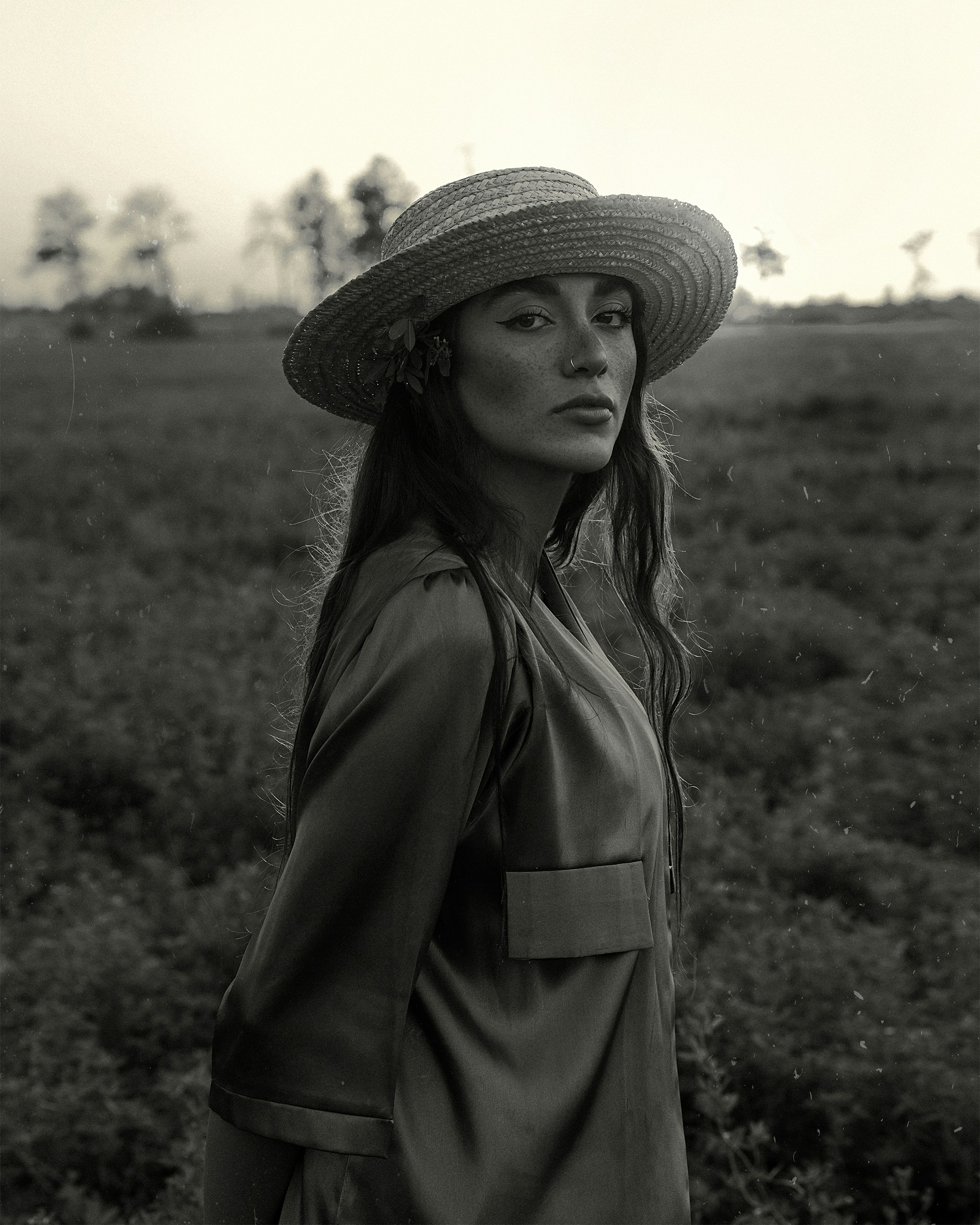 Une femme portant un chapeau debout dans un champ