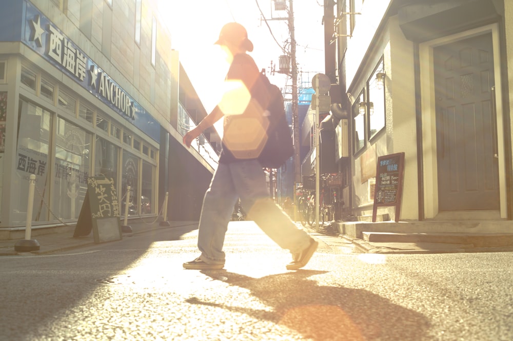 a man walking down a street holding a skateboard