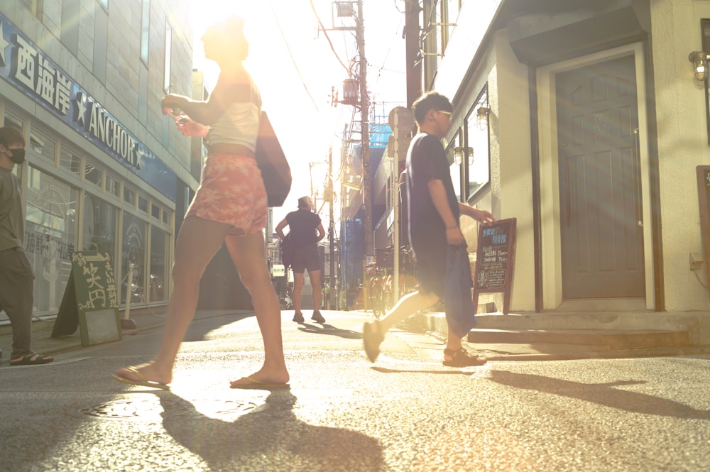 a group of people walking down a street next to tall buildings