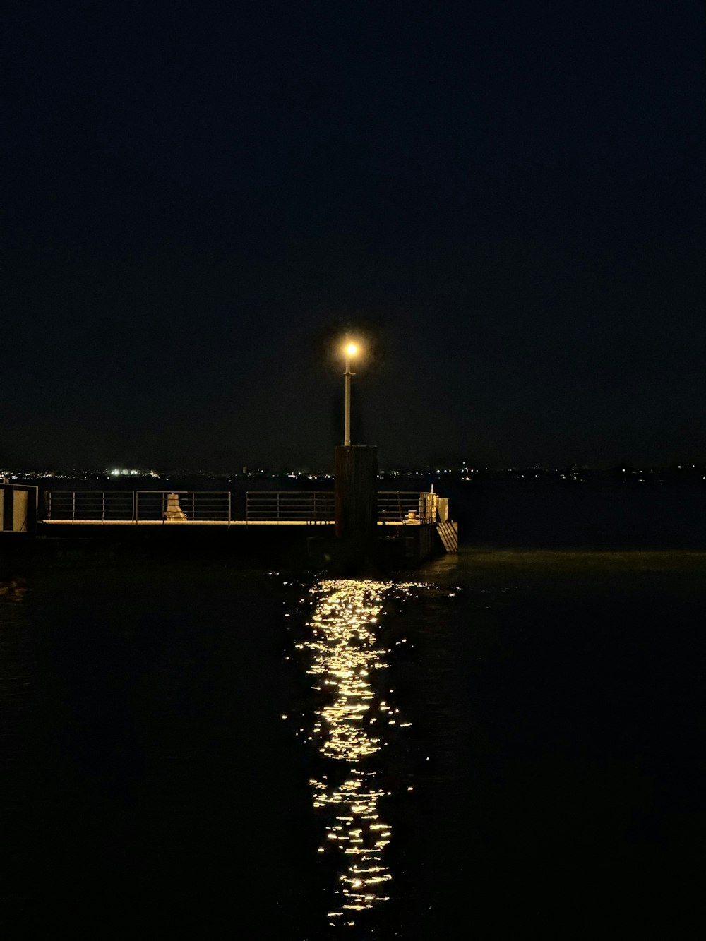 a lighthouse is lit up at night on the water