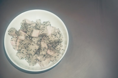 Close-up of vibrant freeze-dried pitahaya fruit pieces in a rustic bowl