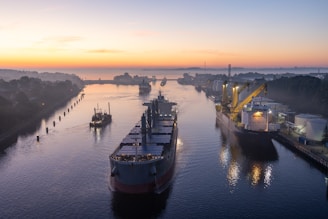 A ship being expertly guided through a busy port at dawn.