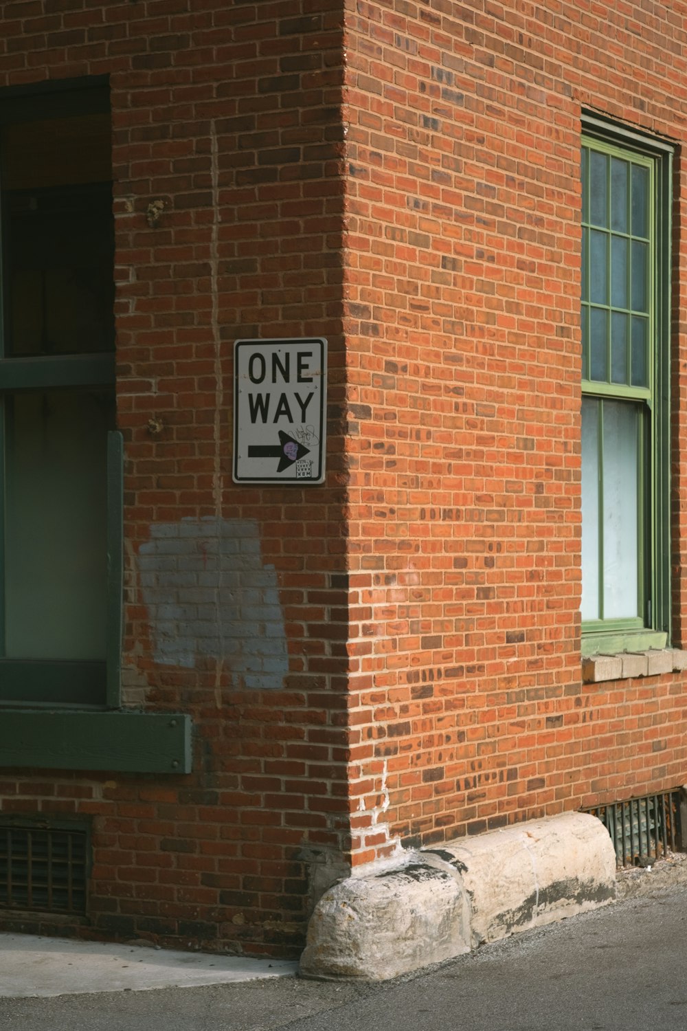 a brick building with a one way sign on it
