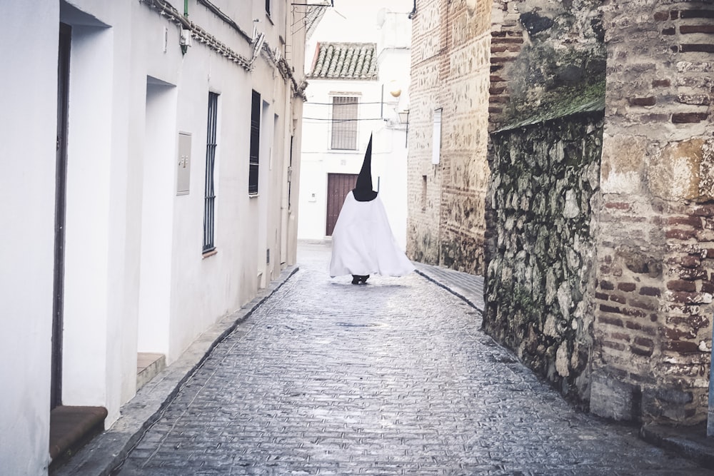 a person walking down a narrow alley way