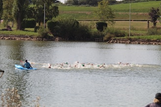 Swimmers navigating a mid-distance open water course with safety kayaks nearby.