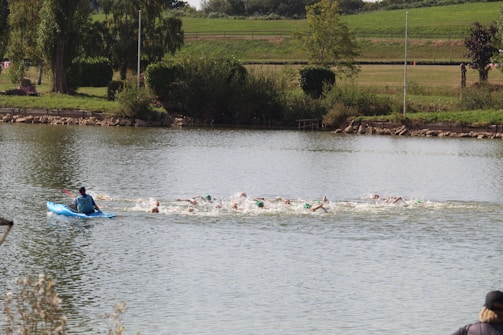 Swimmers navigating a mid-distance open water course with safety kayaks nearby.