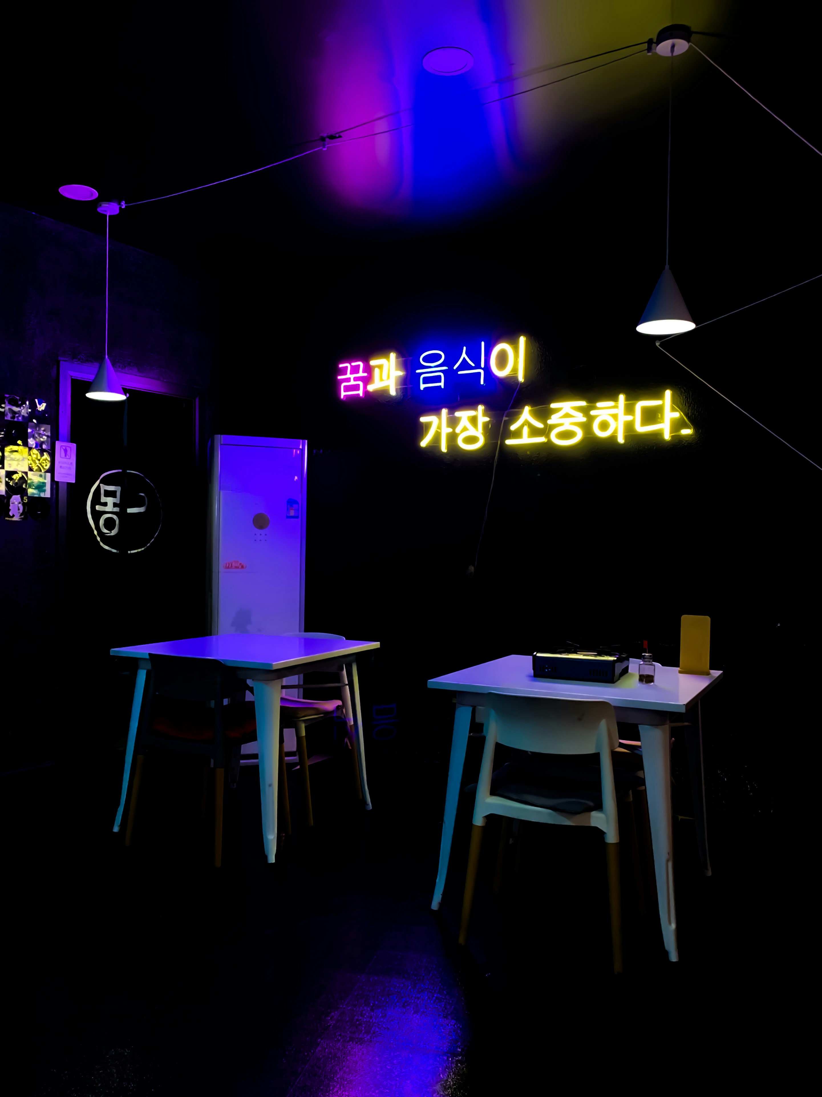 Restaurant bar neon sign glowing in dark atmospheric interior, pink and purple tones