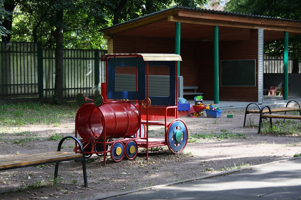 a red train sitting on top of a dirt field