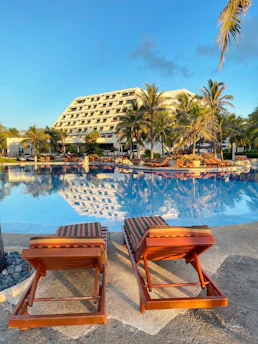 a couple of lounge chairs sitting next to a swimming pool