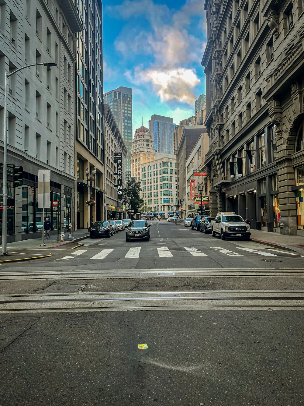 a city street filled with traffic next to tall buildings