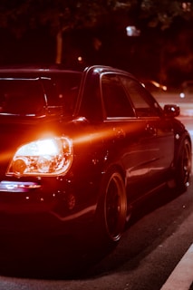 A sleek black car with custom red LED interior lighting glowing vividly at night.