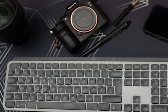 A sleek, dark-themed workspace featuring a Sony Alpha A7 IV camera, lighting setup, and editing screens glowing softly.