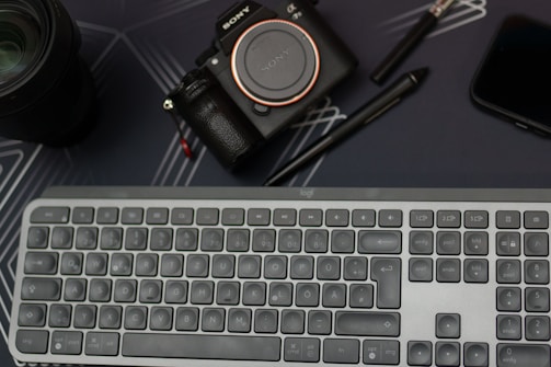 A sleek, dark-themed workspace with a laptop, camera, and drone ready for creative media production.