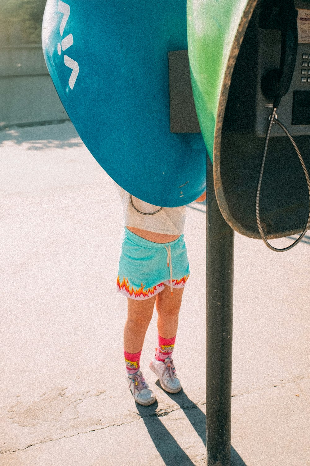 a little girl standing next to a parking meter