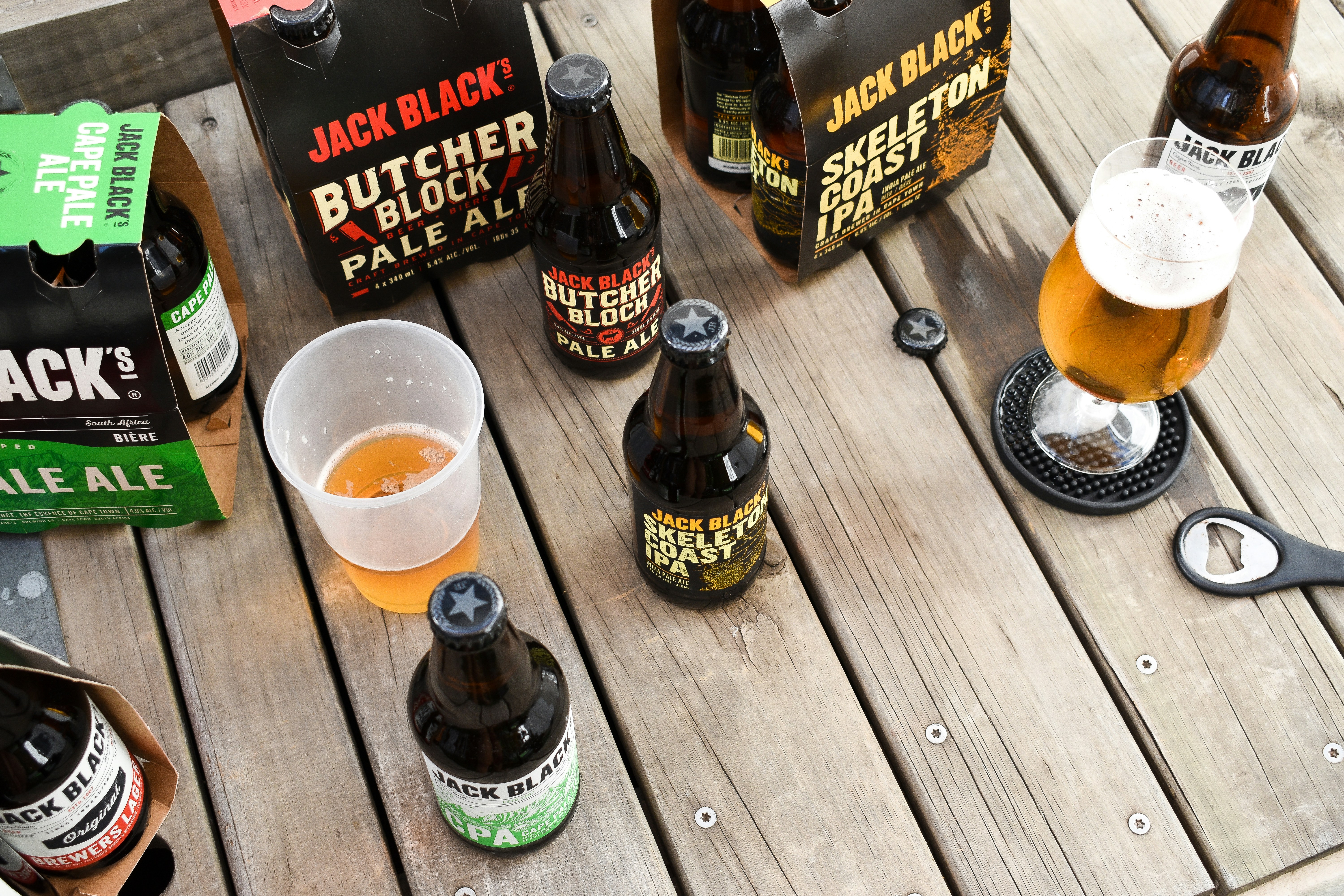 a wooden table topped with lots of bottles of beer