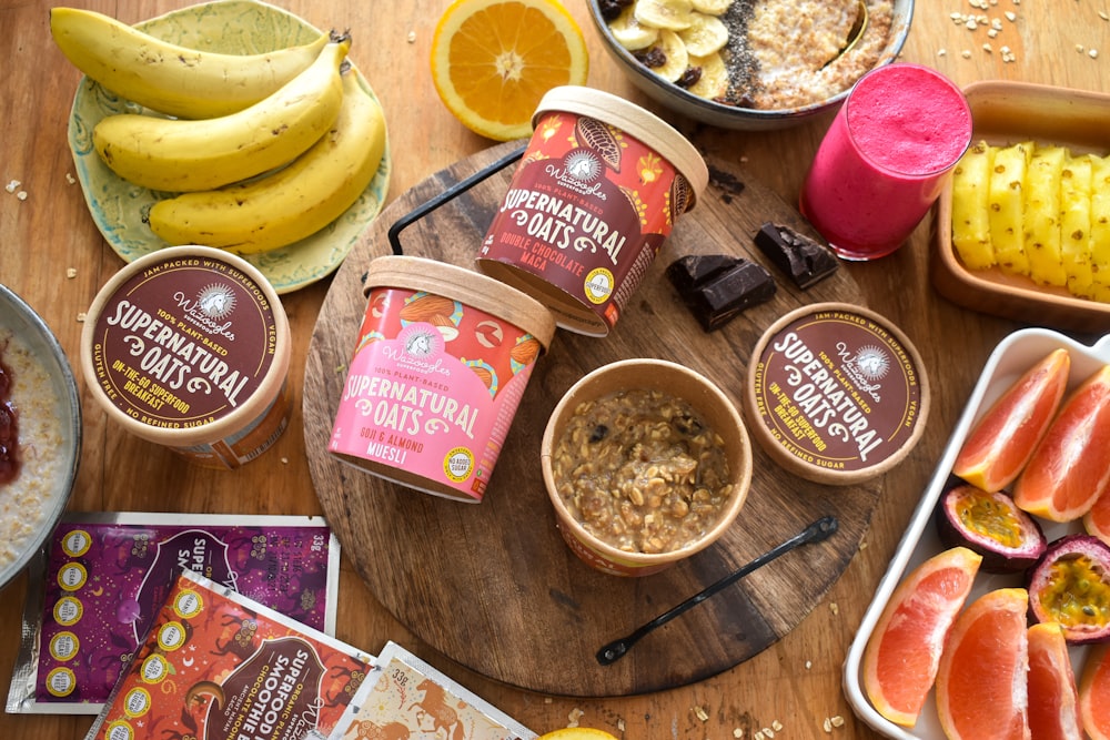 a wooden table topped with bowls of fruit and ice cream