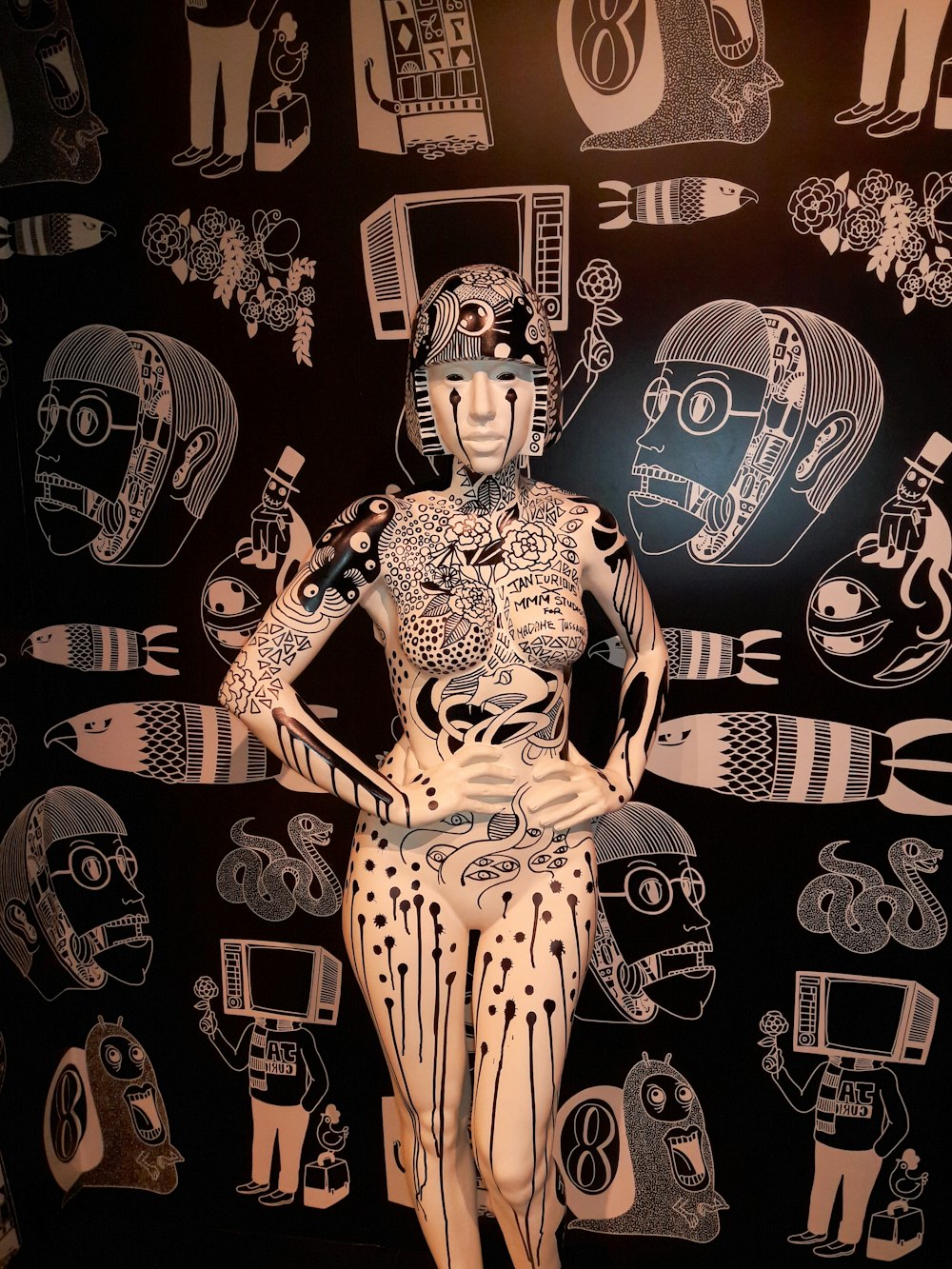 a mannequin is standing in front of a wall with many drawings on it