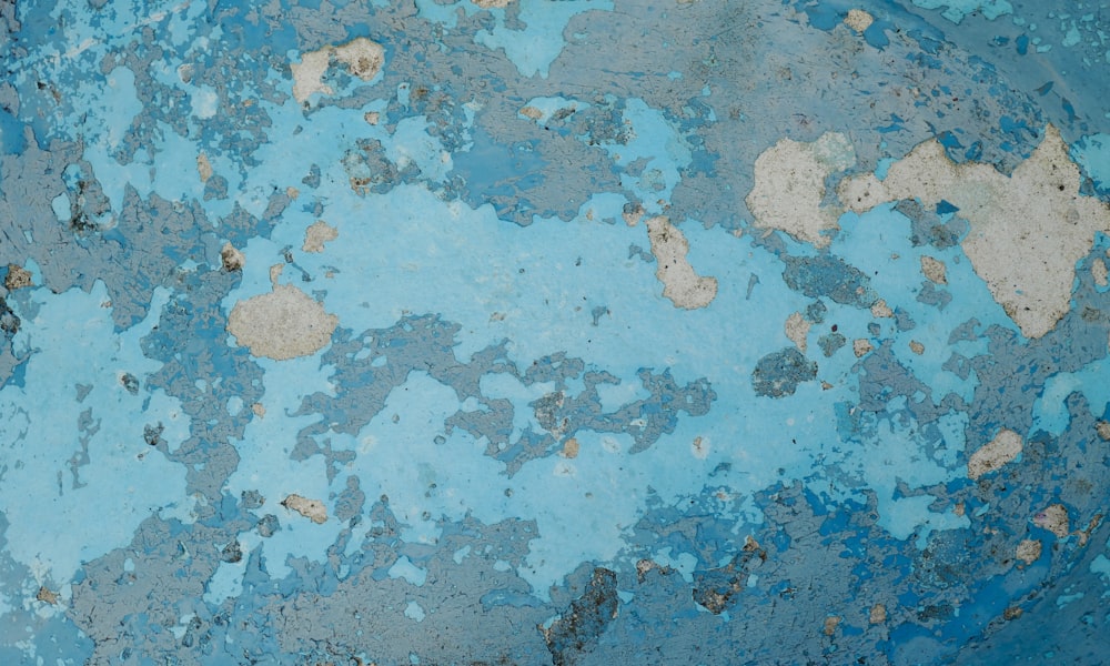 a close up of a blue wall with peeling paint