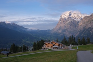 A serene view of a chalet with mountains in the background.