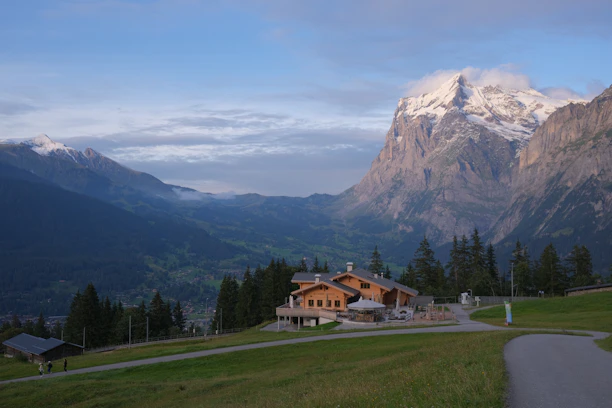 A serene chalet terrace overlooking snow-capped mountains at sunset.