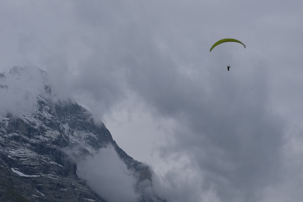 a paraglider is flying over a mountain range