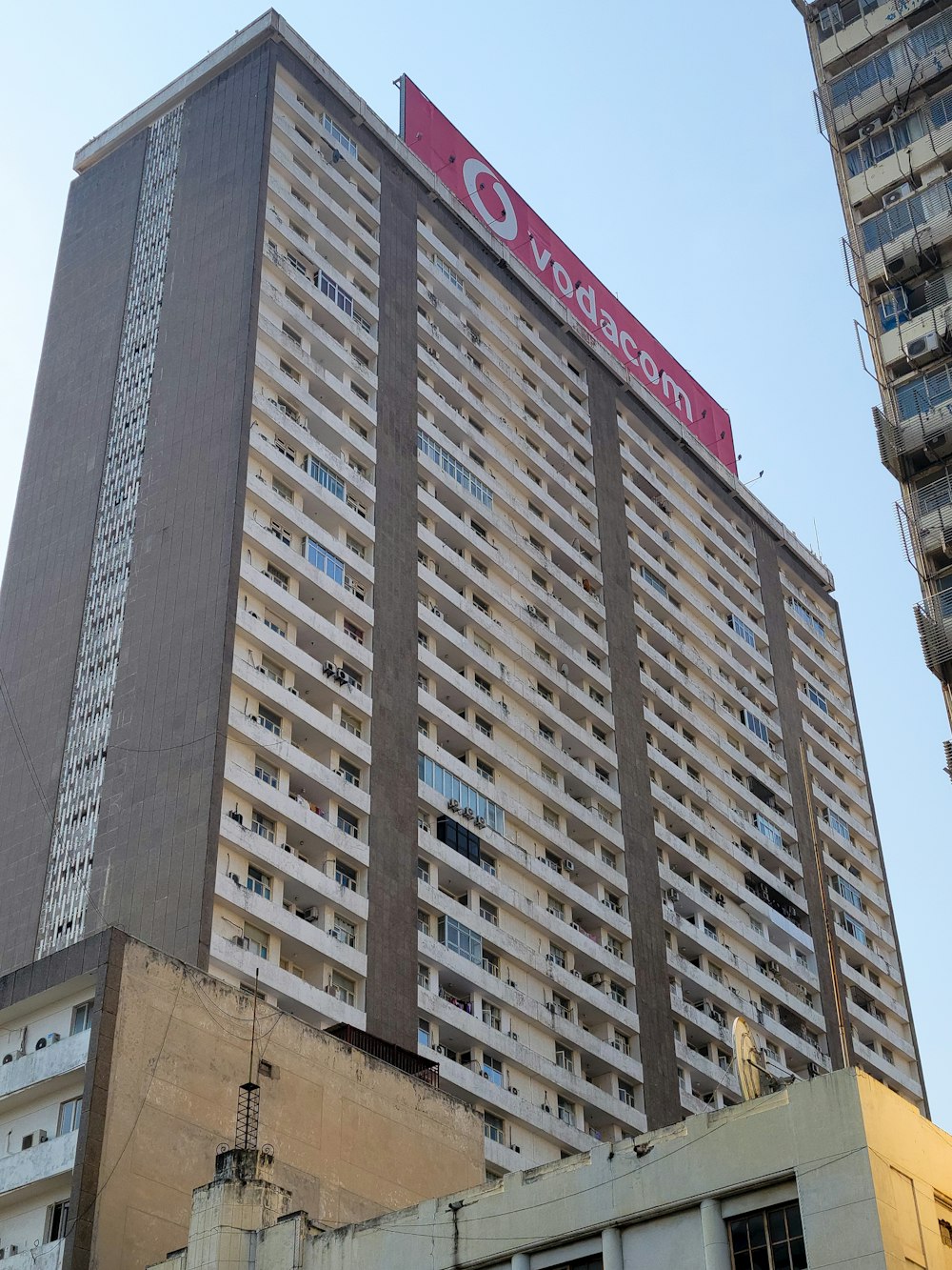 a tall building with a red sign on top of it