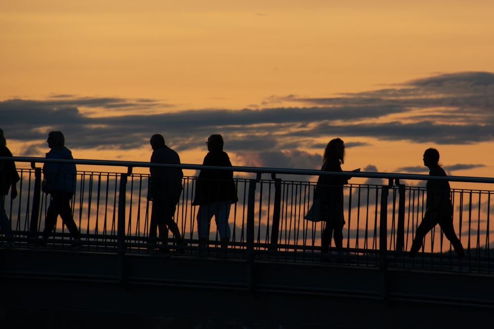 a group of people walking across a bridge