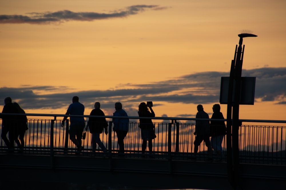 a group of people walking across a bridge