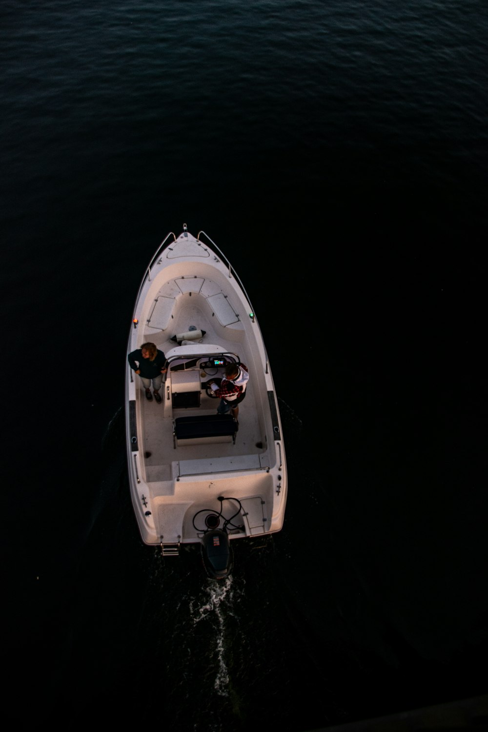 a white boat floating on top of a body of water